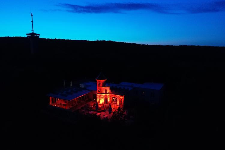 Erleuchtetes Restaurant bei Nacht, links ein Funkturm.