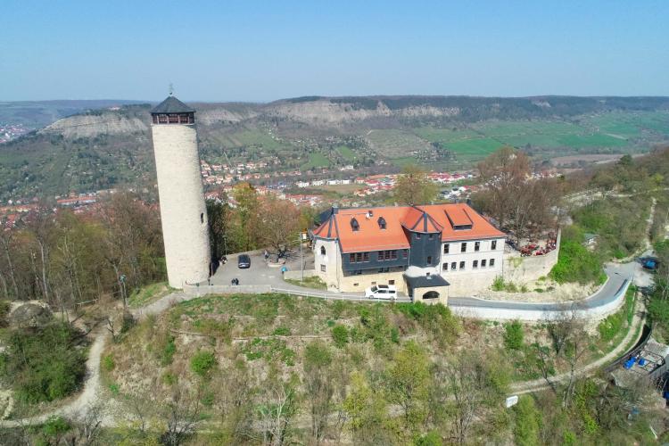 Steinerner Turm auf einer kargen Bergkuppe mit Nebengebäude