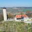 Steinerner Turm auf einer kargen Bergkuppe mit Nebengebäude