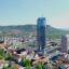 Panoramabild des Stadtkerns Jena, aufgenommen aus der Höhe des JenTowers. Im Zentrum der JenTower, FSU Campus und die Stadtmitte mit Kirche und Marktplatz. An den Rändern Wohngebiete.